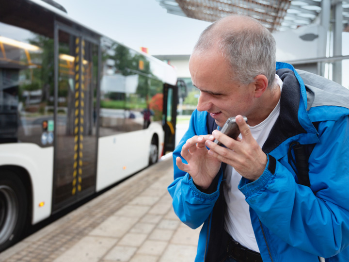 Visually impaired man on street using mobile phone for audible directions