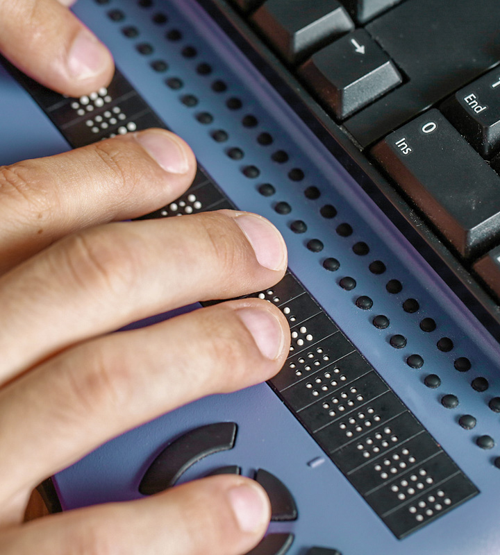 Closeup of hands typing on assistive computer equipment