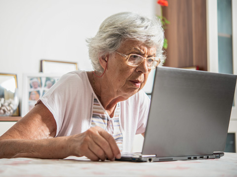 Senior woman having difficulty seeing computer screen