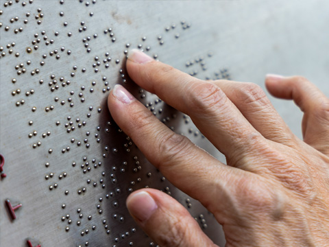 Closeup of hand reading braille