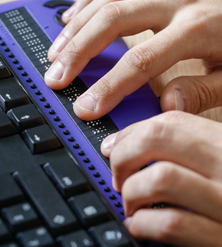 Closeup of hands typing on assistive computer equipment