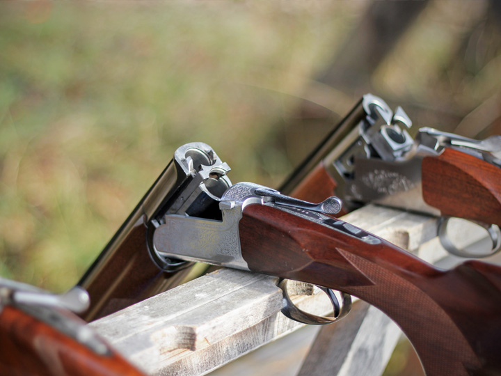 Sporting clays guns rest on a rack waiting for the next round