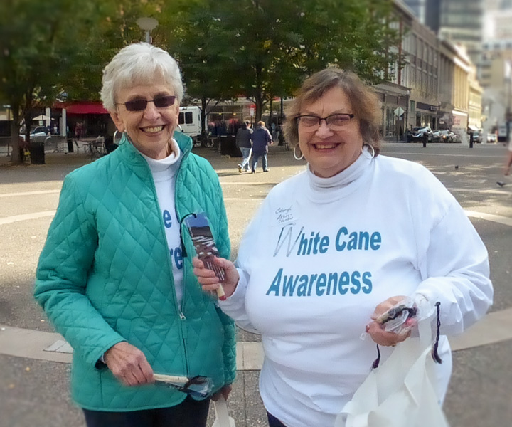 Two visually impaired women participating in the White Cane Awareness event