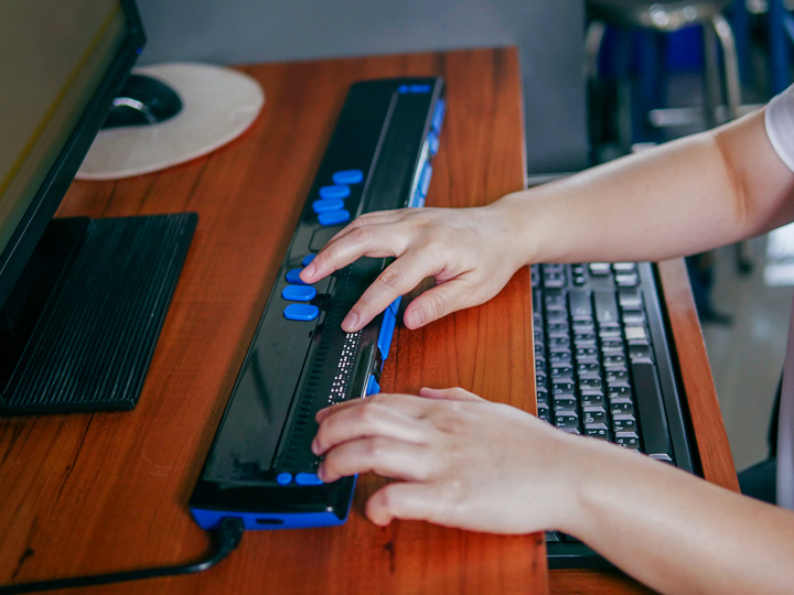 Visually impaired woman learning assistive computer technology