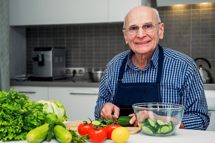 Elderly vision impaired man safely preparing food at home